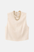 Blouse écru sans manches de MANGO, avec fines rayures verticales et un collier doré décoratif.