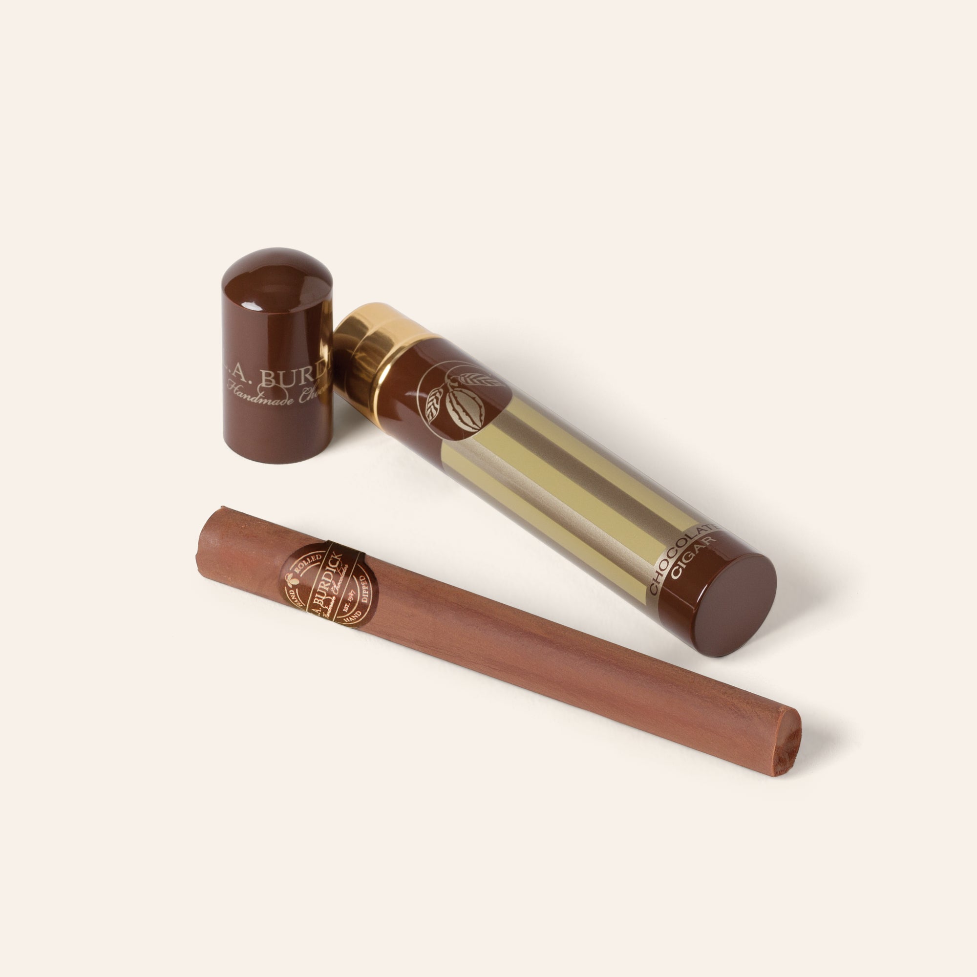 Chocolate Cigar shown next to it's gold cylindrical packaging.