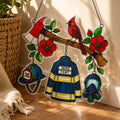 Stained glass decorations featuring a fireman's jacket, helmet, and cardinal bird on a branch.