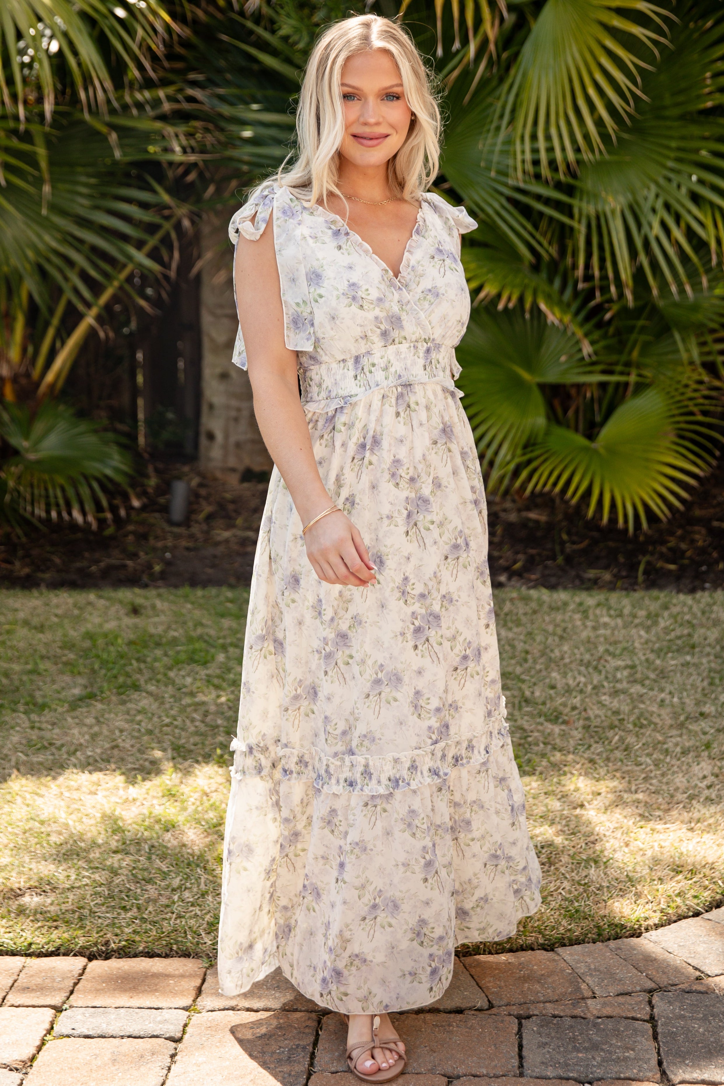 Woman in a floral dress standing in front of tropical plants
